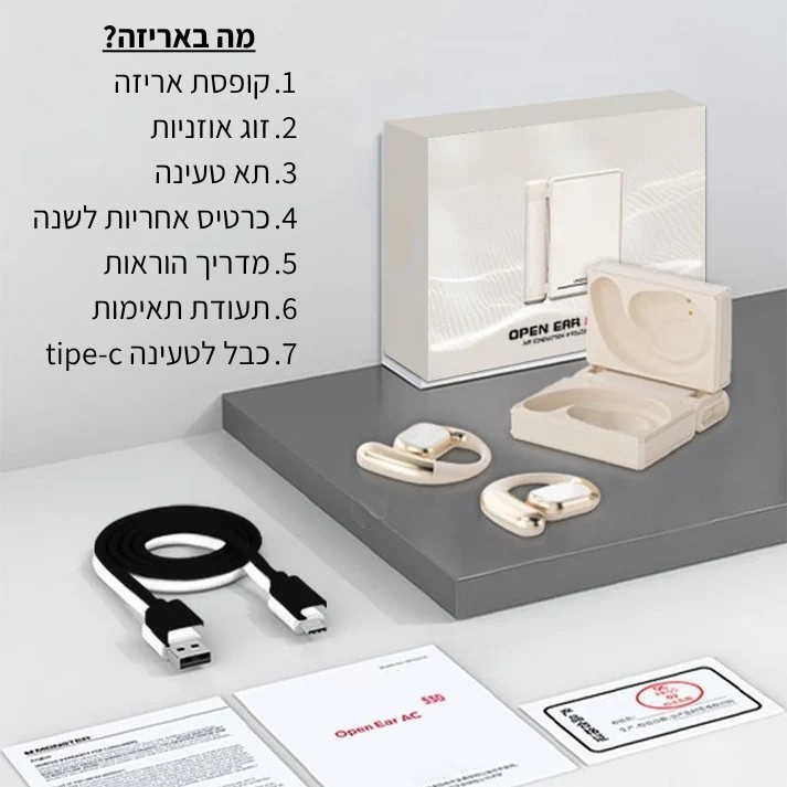Open Ear AC 05 wireless earbuds shown with their cream-colored storage case, a black USB charging cable, a branded retail box, and printed paperwork on a light gray studio background. Hebrew text is printed on the left side of the image.